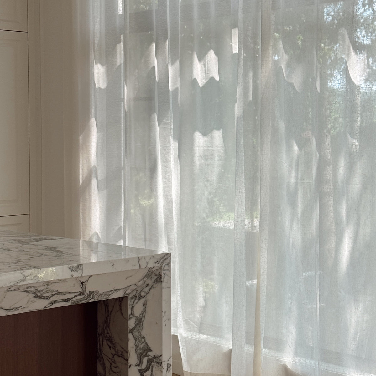 Custom semi-sheer Chantilly cream curtains in Vale Collection by Thoa Home with a marble countertop in modern kitchen.